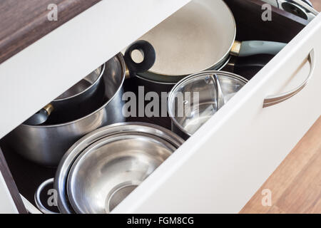 Geöffnete Schublade Schrank mit Stahl Töpfe und Pfannen und Schüssel. Küche Geschirr Hintergrund Stockfoto