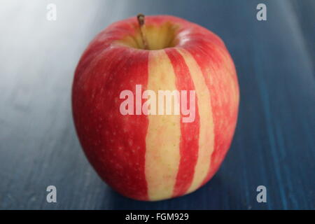 Gestreifter roter Apfel auf blauer Tisch Stockfoto