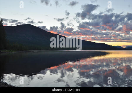 Sonnenaufgang über dem See. Rosa Wolken gemalt durch die aufgehende Sonne spiegelt sich im Wasser des Sees. Stockfoto