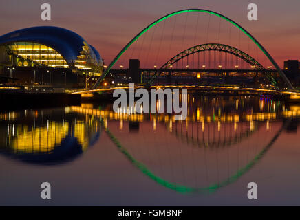 Beleuchtete Tyne Bridge, die Millennium Bridge und den Salbei spiegelt sich in den Fluss Tyne in der Dämmerung Stockfoto