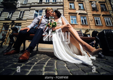 Braut und Bräutigam sitzen auf der Bank Stockfoto