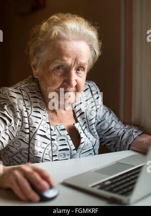 Eine ältere Frau mit Laptop sitzen. Stockfoto