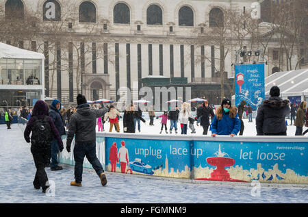 Menschen genießen die freie Natur-Eisbahn im Schnee an der Bank von Amerika Winterdorf im Bryant Park, New York Stockfoto