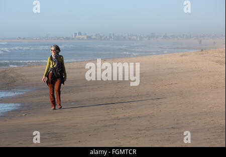 Frau Spaziergänge am Strand, U.S. / Mexiko Grenze in der Nähe von San Ysidro, Kalifornien in den Tijuana River Estuarine Research Nationalreservat Stockfoto