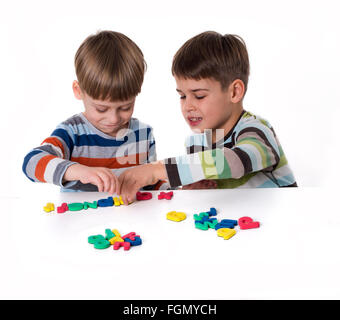 zwei Jungs spielen mit den Kunststoff-Buchstaben Stockfoto