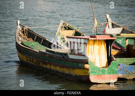 Traditionelle Holzfischerboote Panama Bay Panama-Stadt Panama | PANAMA-STADT, Panama — Ein bunt bemaltes Holzfischerboot, dessen Bug mit der Registrierung „8PA 1919“ gekennzeichnet ist, schwebt zusammen mit ähnlichen Schiffen entlang der Ufergegend von Panama Bay. Die Bucht, Teil des Golfs von Panama, bleibt ein Arbeitszentrum für handwerkliche Fischereiflotten, die seit Generationen von dieser Küste aus operieren. Die handbemalten Farben und das geflickte Segeltuch unterscheiden diese traditionellen Boote von den modernen Hafenbooten in der Nähe. Stockfoto