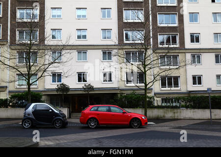 Kleine Volkswirtschaft Kleinwagen Stadtauto parkte neben BMW außerhalb Wohnungen in Exhibition Road, Kensington, London, England Stockfoto