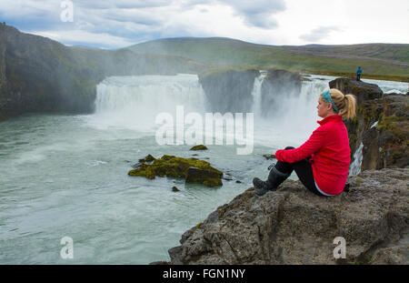 Island Godafoss Wasserfälle Wasserfälle in North Central Island auf der Ringstraße mit Touristen sitzen in rot Modell veröffentlicht MR-3 Stockfoto