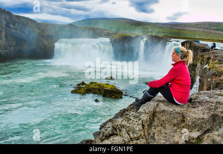 Island Godafoss Wasserfälle Wasserfälle in North Central Island auf der Ringstraße mit Touristen sitzen in rot Modell veröffentlicht MR-3 Stockfoto