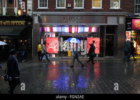 Menschen zu Fuß vorbei an Kiko Milano Kosmetik speichern an einem regnerischen Januarabend, in der Nähe von Covent Garden, London, England Stockfoto