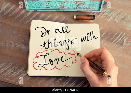 Retro-Effekt und getönten Bild einer Frau hand schreiben eine Notiz mit einem Füllfederhalter auf einem Notebook. Motivations-Konzept mit handschriftlichen Text alle Dinge mit Liebe zu tun Stockfoto