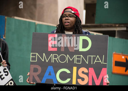 Harlem, New York, USA. 21. Februar 2016. Ein Aktivist hält ein Schild Oppossing Klimarassismus bei Solidaritätskundgebung für Flint, Michigan in Harlems Adam Clayton Powell Jr. State Office Building. Stockfoto