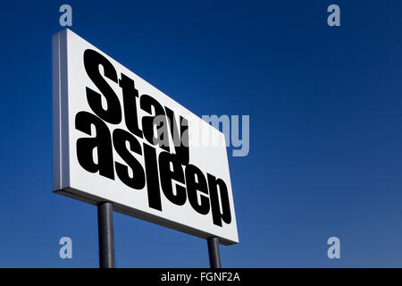 Große Anzeige-Panel, geprägt mit der Meldung "Durchzuschlafen", isoliert auf blauen Himmel. Stockfoto