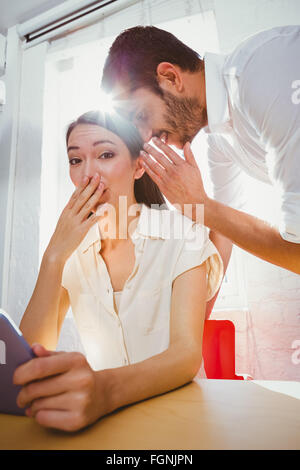 Mann, die geheime Freunde Ohr flüstern Stockfoto