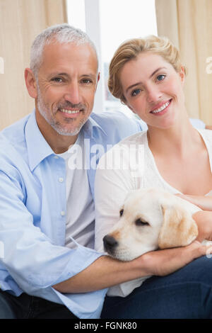 Brautpaar mit Welpen auf Sofa kuscheln Stockfoto