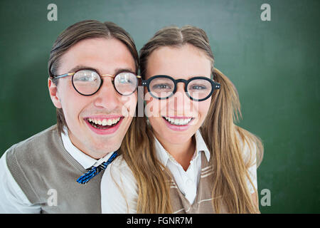 Zusammengesetztes Bild von geeky Hipster lächelnd in die Kamera Stockfoto