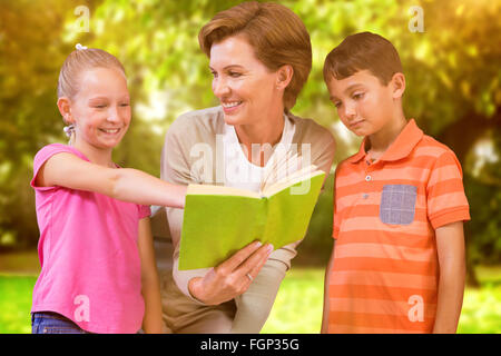 Zusammengesetztes Bild des Lehrers Buch mit Schülerinnen und Schülern in Bibliothek Stockfoto