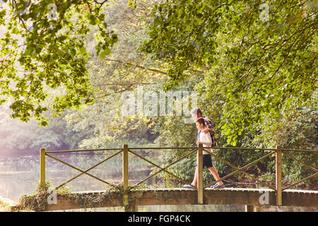 Vater und Sohn Kreuzung Fußgängerbrücke im Park mit Bäumen Stockfoto