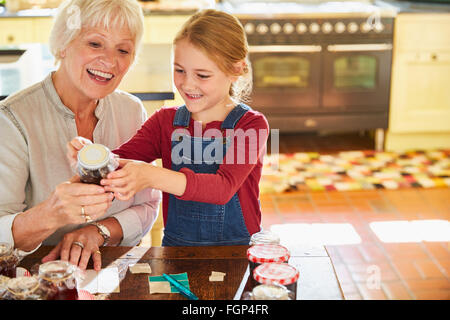 Großmutter und Enkelin Kennzeichnung canning-Gläser in der Küche Stockfoto