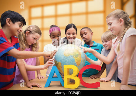 Zusammengesetztes Bild der niedlichen Schüler und Lehrer im Globe in Bibliothek suchen Stockfoto