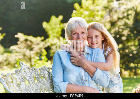 Porträt, Lächeln, Großmutter und Enkelin umarmt im Garten Stockfoto