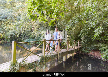 Familie Kreuzung Fußgängerbrücke im Park mit Bäumen Stockfoto