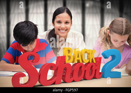 Zusammengesetztes Bild der hübschen Lehrerin helfen Schülern in Bibliothek Stockfoto