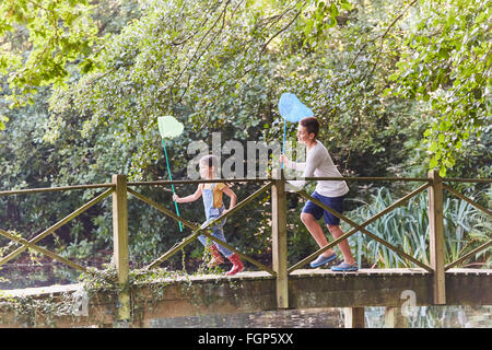 Bruder und Schwester mit Schmetterling Netze am Steg im park Stockfoto