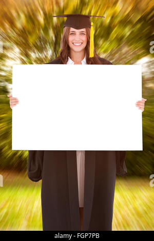 Zusammengesetztes Bild voller Länge einer Frau mit einem leeren Blatt vor ihr wie sie lächelt Stockfoto