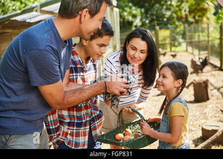 Familie, die Ernte von frischer Eiern von Hühnern außerhalb coop Stockfoto