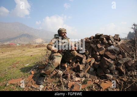 Srinagar. 22. Februar 2016. Ein Soldat der indischen Armee nimmt Stellung in der Nähe eine Schießerei am Stadtrand von Srinagar, 22. Februar 2016. Eine intensive Schießerei zwischen Truppen und militanten besetzen ein Regierungsgebäude in unruhigen Indien kontrollierten Kaschmir Montag dritten geraden Tag eingegeben, sagten Beamte. © Javed Dar/Xinhua/Alamy Live-Nachrichten Stockfoto