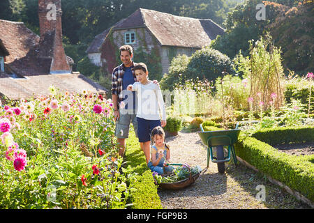 Familie im sonnigen Garten Blumen pflücken Stockfoto