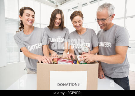 Lächelnde Freiwilligen Sortierung Spendenbox Stockfoto