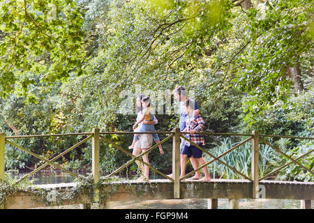 Familie Kreuzung Fußgängerbrücke im Park mit Bäumen Stockfoto