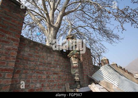 Srinagar. 22. Februar 2016. Ein Soldat der indischen Armee nimmt Stellung in der Nähe eine Schießerei am Stadtrand von Srinagar, 22. Februar 2016. Eine intensive Schießerei zwischen Truppen und militanten besetzen ein Regierungsgebäude in unruhigen Indien kontrollierten Kaschmir Montag dritten geraden Tag eingegeben, sagten Beamte. © Javed Dar/Xinhua/Alamy Live-Nachrichten Stockfoto