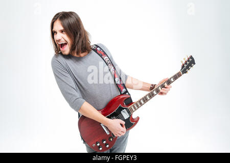 Verrückte begeistert jungen Mann schreien und e-Gitarre zu spielen, auf weißem Hintergrund Stockfoto