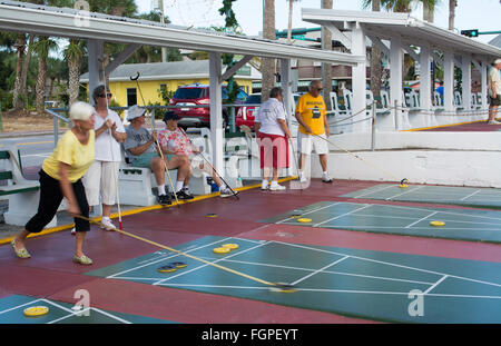 New Smyrna Beach Florida Senior im Ruhestand Paare spielen Shuffleboard im Spiel Wettbewerb in der Stadt an der Flaglaer Street Stockfoto