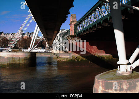 Ein Blick von unten Golden Jubilee Bridge, London, England, mit Hungerford Eisenbahnbrücke auf der rechten Seite. Stockfoto