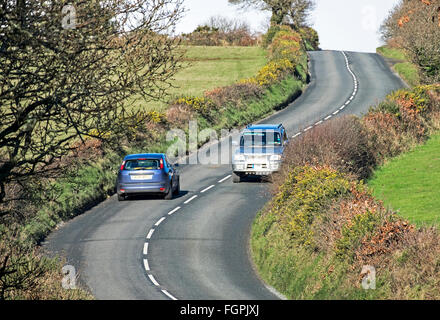 Zwei Fahrzeuge in einer Kurve auf einer Landstraße in Cornwall, Großbritannien Stockfoto