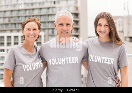 Freiwillige, die Arme umeinander lächelnd Stockfoto