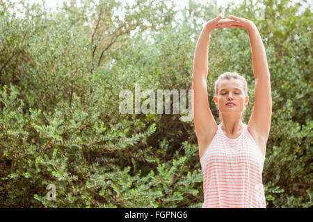 Blonde Sportler Strecken Arme mit geschlossenen Augen Stockfoto