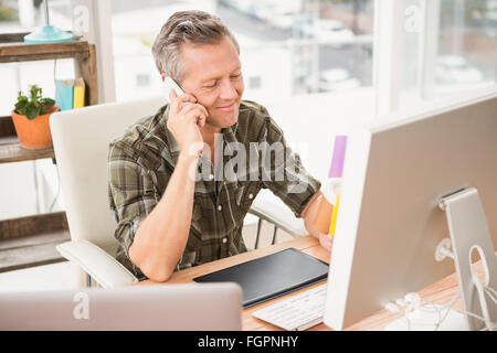Lächelnde lässige Geschäftsmann mit einem Anruf Stockfoto