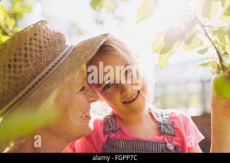 Porträt lächelnd Enkelin mit Großmutter im sonnigen Garten Stockfoto