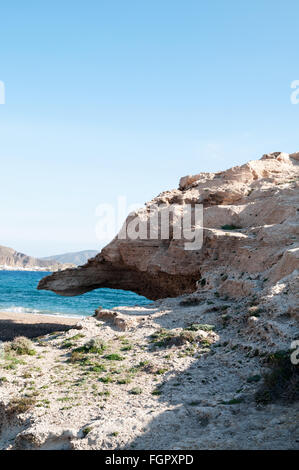 Vulkanische Felsformationen in Los Escullos, Nationalpark Cabo de Gata mit kleinen Fischerdorf Dorf von Isleta del Moro im hinteren Stockfoto