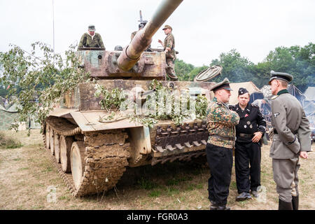 Re-enactment. Zweiter Weltkrieg deutsche Tiger Tank Mark 1, mit Kommandant vor Gespräch mit zwei Deutschen Kapitäne, einer in der Tarnung uniform. Stockfoto