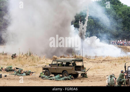 Krieg und Frieden zeigen. Vietnam Krieg Re-enactment. Amerikanischen Marines, die Abdeckung gerade nach der großen Explosion bei Brand-bekämpfung mit Viet-con. Publikum. Stockfoto