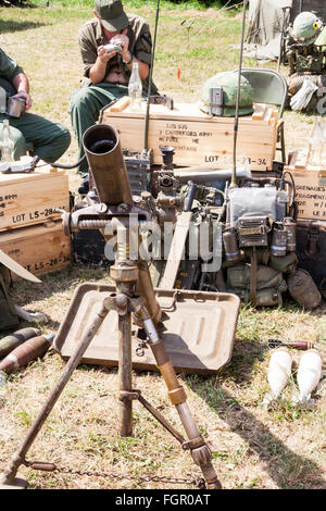 Vietnam Krieg Re-enactment. American heavy Mörtel in sandbagged Position mit verschiedenen Geräten an der Rückseite gegen Kisten gestapelt. Einige Soldaten entspannend. Stockfoto