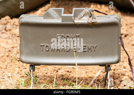 Vietnam Krieg Re-enactment. M18 Claymore Mine mit M4 strahlen Cap als booby Trap knapp über dem Boden einstellen. Auf Metallgehäuse, "Front in Richtung Feind'. Stockfoto