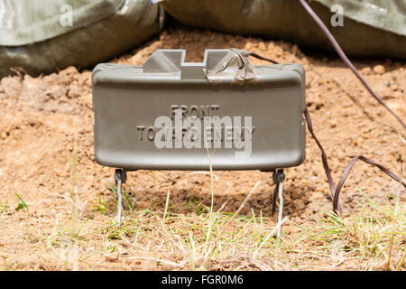 Vietnam Krieg Re-enactment. M18 Claymore Mine mit M4 strahlen Cap als booby Trap knapp über dem Boden einstellen. Auf Metallgehäuse, "Front in Richtung Feind'. Stockfoto