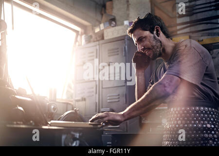 Reden über Handy in Schmiede Schmied Stockfoto